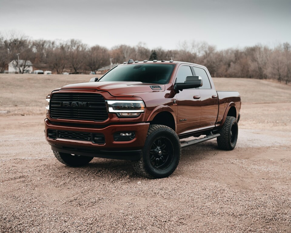 red Chevrolet crew cab pickup truck on dirt road during daytime